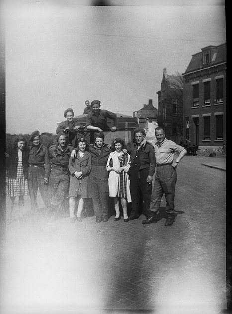 Групповой портрет британских военных из 51-й высокогорной дивизии и американского радиста на улице города. Нидерланды, 1944 год.