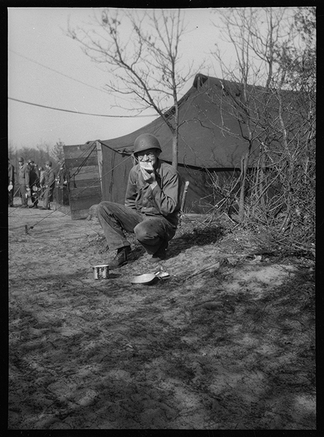 Американский солдат обедает в расположении армейского полевого лагеря. Нидерланды, 1944 год.
