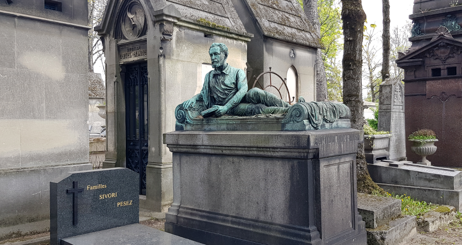 Еще одно надгробие belle epoque, изображающее погребенного под ним человека. Полулежащий, изнуренный болезнью, он до последнего не оставляет своих занятий, очевидно научных (судя по книге в его руках).