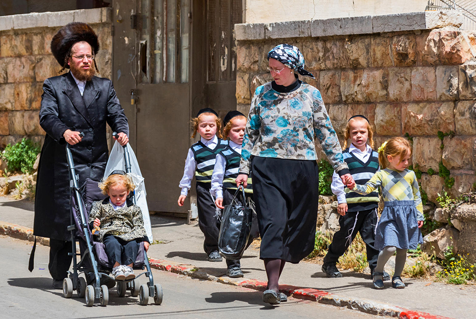 Религиозная еврейка с семьей в квартале Меа-Шеарим в Иерусалиме
