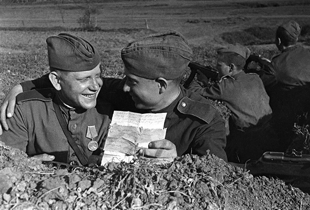 Солдаты в окопе читают письмо от родных