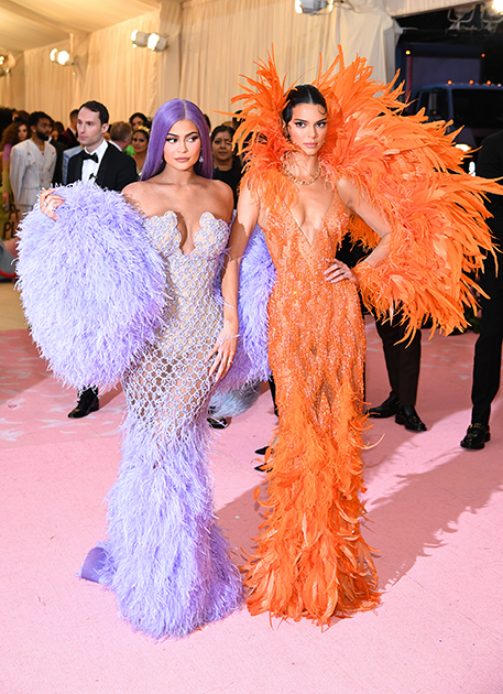 Сестры Кайли и Кендалл Дженнер оделись райскими птицами — или героинями парижских кабаре — в цветных перьях от Versace.