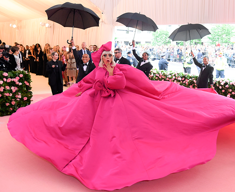 Главным цветом вечера стал самый, пожалуй, эксцентрический и манерный оттенок в мире — цвет фуксии, а звездой вечера (и это уже стало привычным) — певица Леди Гага. Неудивительно: она признанная «королева camp», ее образы часто скатываются в бурлеск. Леди Гага явилась на красную дорожку в широченном платье Brandon Maxwell с бантом в волосах в тон. 