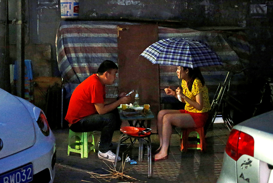 Китайская культура стрит-фуда стара и богата. В КНР существует множество блюд, которые принято есть на улице и на ходу. На фото пара перекусывает в одном из уличных ресторанов Пекина. 