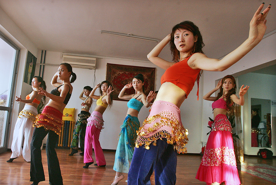 Все больше китаянок идут в танцевальные классы, чтобы научиться танцевать нетипичные для китайской культуры виды хореографии. Например, эти девушки на фото изучают танец живота в одной из танцевальных школ Пекина.