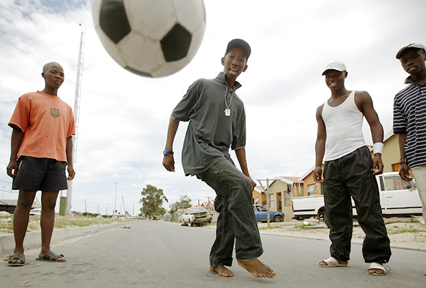 Молодежь играет в футбол на улицах района Хайелитш в Кейптауне