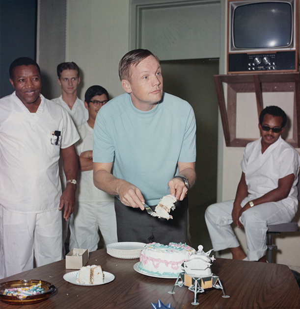 5 августа Армстронг отметил свое 39-летие в Центре пилотируемых космических полетов (современный Космический центр Джонсона) в Хьюстоне (Техас). На заднем плане снимка — вспомогательный персонал центра, на столе торт и модель лунного модуля Apollo 11.