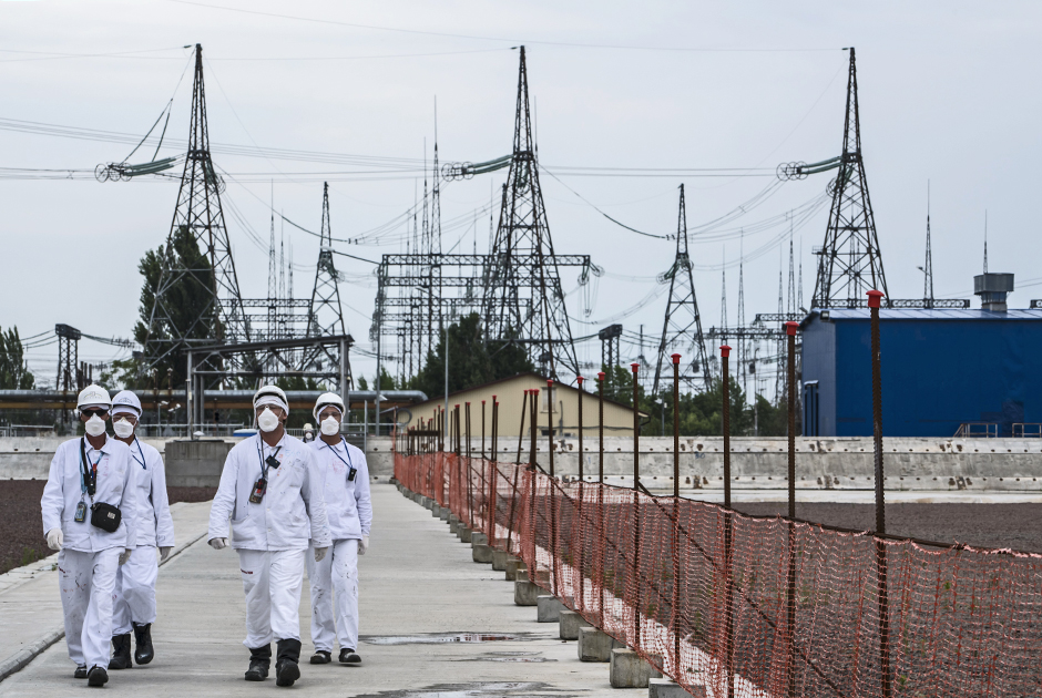 В фильмах, сериалах и на снимках, сделанных сталкерами и туристами, Чернобыльская АЭС всегда выглядит заброшенным монстром. На самом деле здесь постоянно работают люди — защитные конструкции тоже кто-то должен обслуживать.Современный купол над злосчастным 4-м реактором получил красивое название «Новый безопасный конфайнмент» (англ. New Safe Confinement, НБК). Его начали строить еще в 2007-м, а ввести в эксплуатацию планировали в 2012-2013 годах. Но реализация проекта затянулась из-за проблем с финансированием.