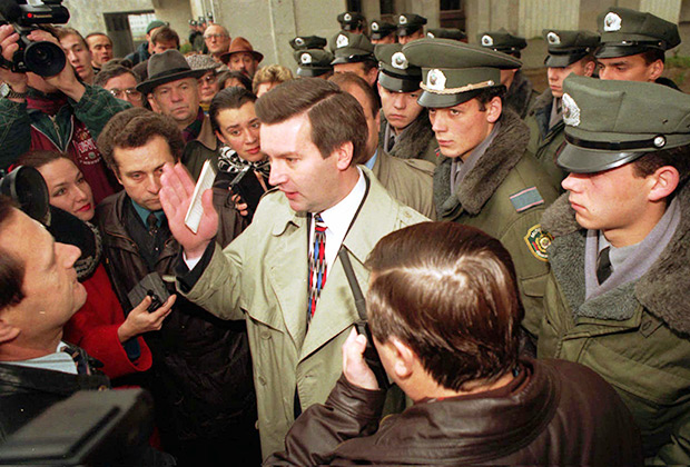 Глава ЦИК Белоруссии Виктор Гончар беседует с журналистами. Сотрудники милиции блокируют вход в здание ЦИК в Минске, 1996 год
