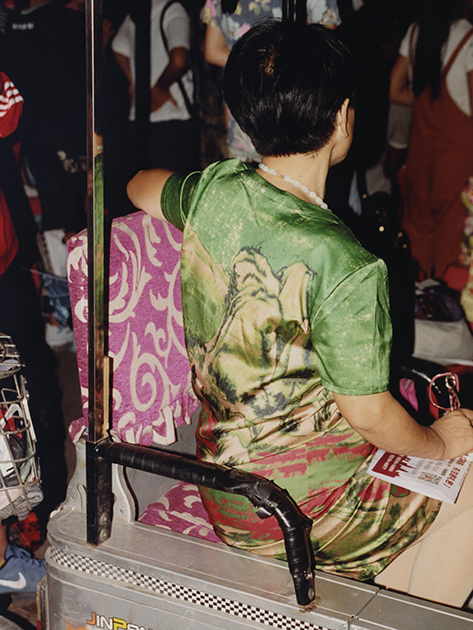 Женщина в общественном транспорте одета в платье с особым рисунком — репринтом картины классического китайского пейзажа.