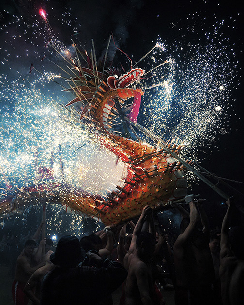 «Фотография сделана на празднике фонарей в городе Бужай. Еще со времен династии Цинь в этом небольшом южном городе во время праздника выделяют отдельное выступление с танцующим драконом. Этого огромного огненного дракона с фейерверками по всему телу несут 30 взрослых мужчин».

