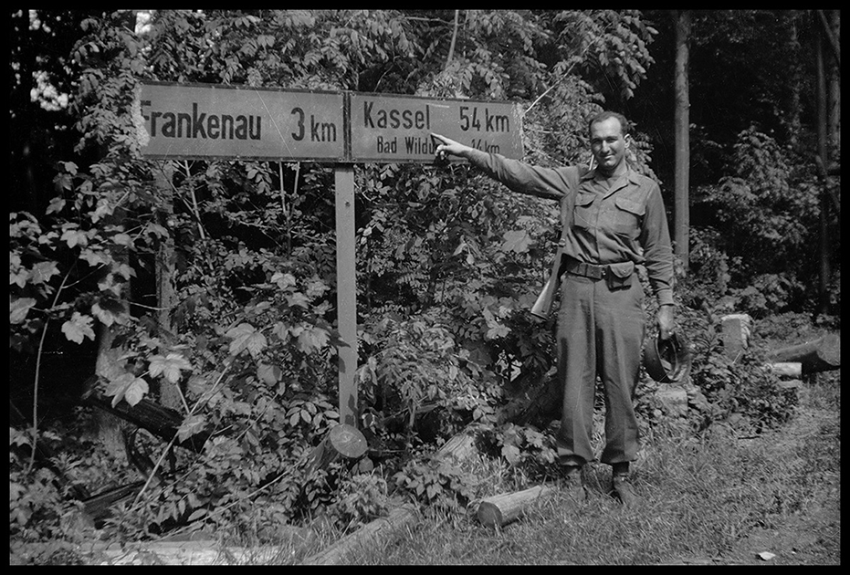 Американский солдат возле дорожного знака. Германия, 1945 год.