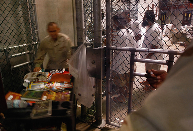 Тюремный охранник приносит книги заключенным