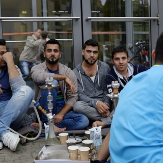 Выходцы с Ближнего Востока у центра приема беженцев в Гамбурге