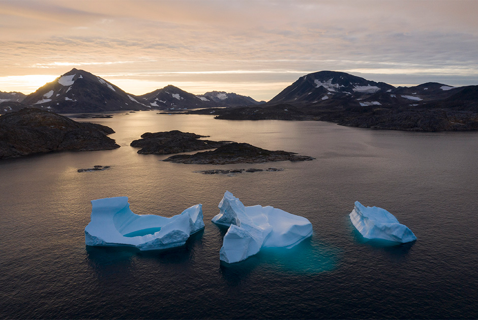 На этой фотографии, сделанной 16 августа 2019 года, запечатлены большие айсберги во время рассвета над поселком Кулусук в Гренландии. 