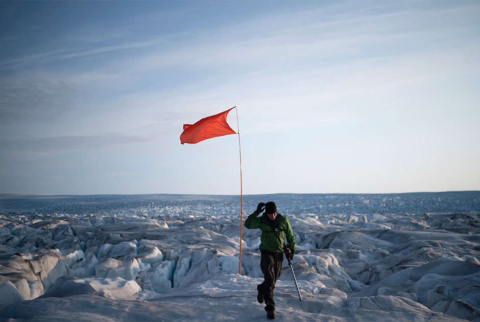 Полевой сотрудник по вопросам безопасности Брайан Ружо (Brian Rougeux) из Нью-Йоркского университета помогает определить GPS-координаты ледника Хелхейм в Гренландии. Лето 2019 года оказалось экстремально теплым для острова, вызвав интенсивное таяние. По расчетам, к концу лета ледники могут потерять 440 миллиардов тонн льда.