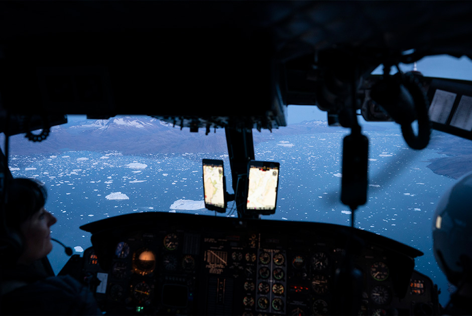 Вертолет пролетает над сотнями айсбергов, плавающих у ледника Хелхейм.