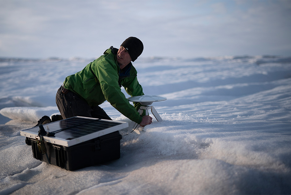 Брайан Ружо устанавливает GPS-антенну на ледник Хелхейм.