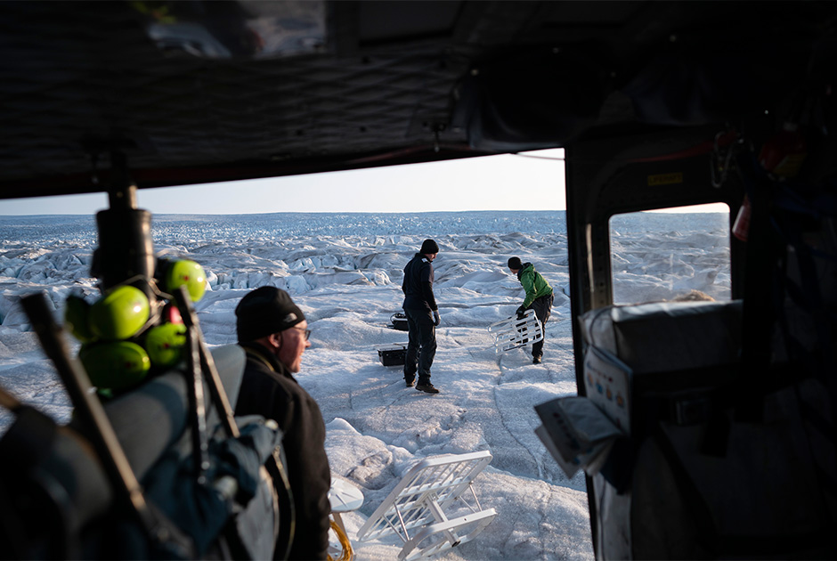 Ученый из Нью-Йоркского университета Дэвид Холленд (David Holland), Брайан Ружо и пилот Мартин Норрегаард (Martin Norregaard) выносят из вертолета антенны, которые будут установлены на ледник. 