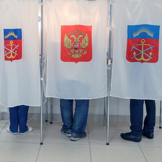 Избиратели в кабинах для голосования на избирательном участке