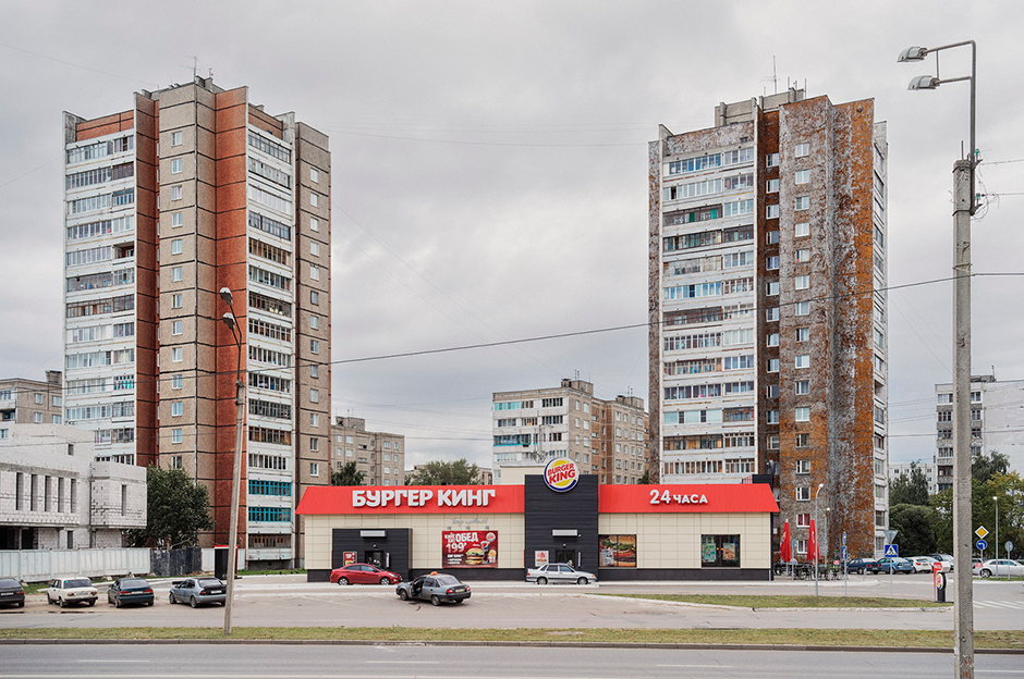 Современное и прошлое — тоже важная составляющая в работах Лукьянова. На одних снимках это незаметно, на других, как на этом, более очевидно. Посередине заведение с американским фастфудом, а вокруг — типовая застройка советского времени. Ландшафт показывает не просто историю, но и то, как изменилась жизнь местных жителей.