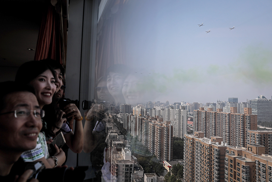 Жители Пекина наблюдают за воздушной частью парада