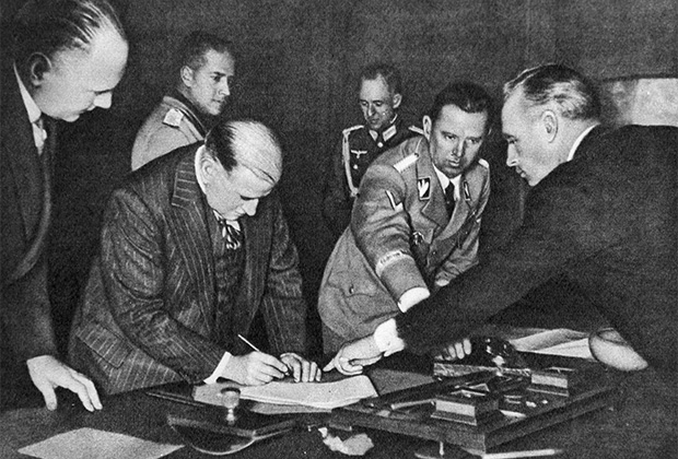Иоахим фон Риббентроп показывает Эдуарду Даладье место для подписи. Подписание Мюнхенского соглашения 30 сентября 1938 года