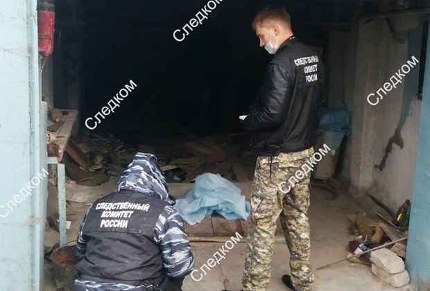 Сотрудники СКР во время осмотра гаража, где была убита девятилетняя девочка