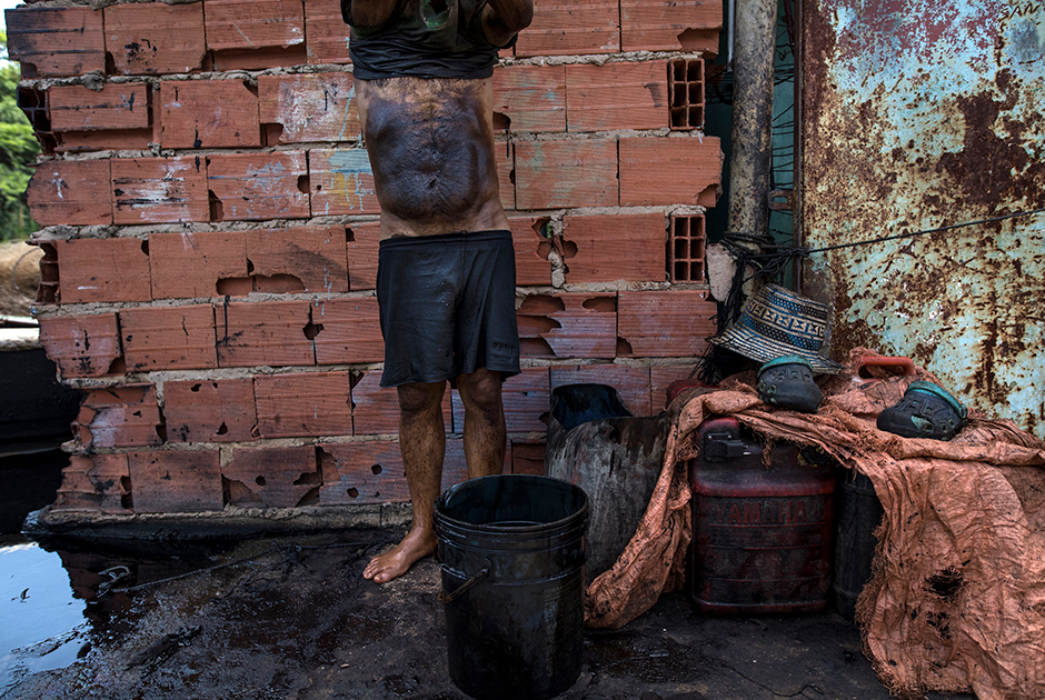 Рыбак Мануэль Нуне в нефти готовится отмываться после ловли крабов. Для этого используют сырой бензин