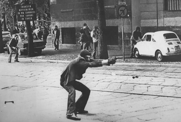 Участник протеста целится из пистолета в полицейских. Милан, 1977 год