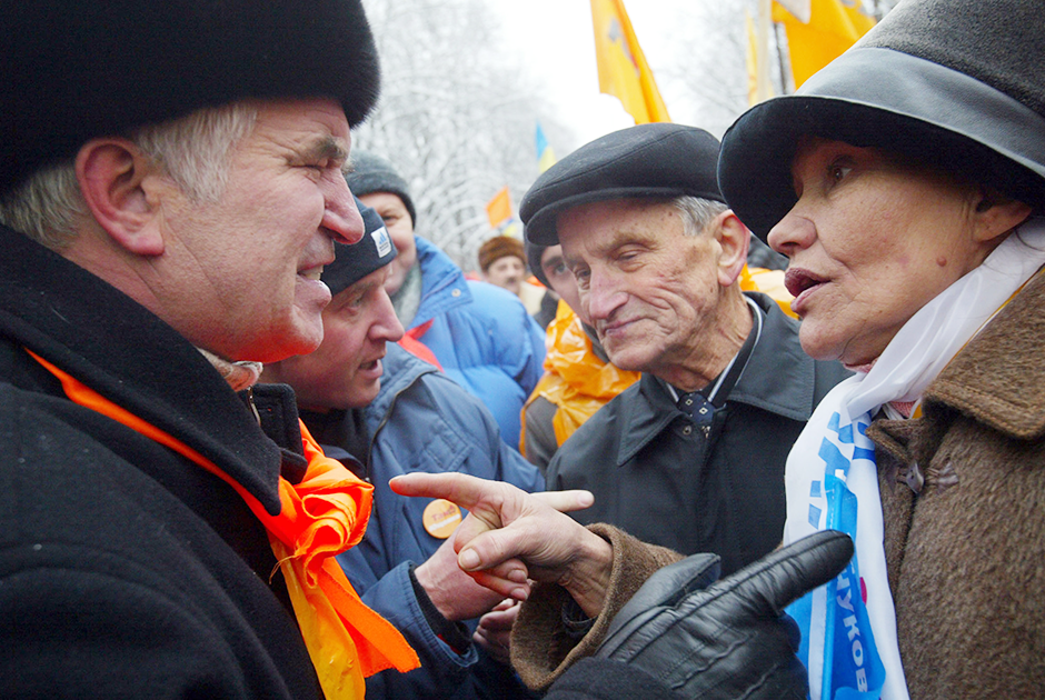 Сторонник Виктора Ющенко (с оранжевым шарфом) спорит со сторонницей Виктора Януковича (в бело-синем шарфе)
