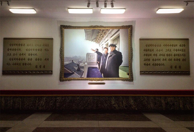 Совместный фотопортрет Ким Ир Сена и Ким Чен Ира в Народном дворце учебы в Пхеньяне. По бокам от фотопортрета — цитаты вождей