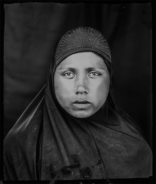 Серия «Когда дом не позволяет остаться» Шахрии Шармин посвящена мусульманскому народу рохинджа. С 2017 года более 700 тысяч представителей этой этнической группы бежали из Мьянмы в Бангладеш, спасаясь от этнических чисток. Шармин пытается не только показать жизнь беженцев, но и рассказать миру их полные боли и горя истории. На фото — 25-летняя Сеновара, младший брат которой был убит военными у нее на глазах. 
