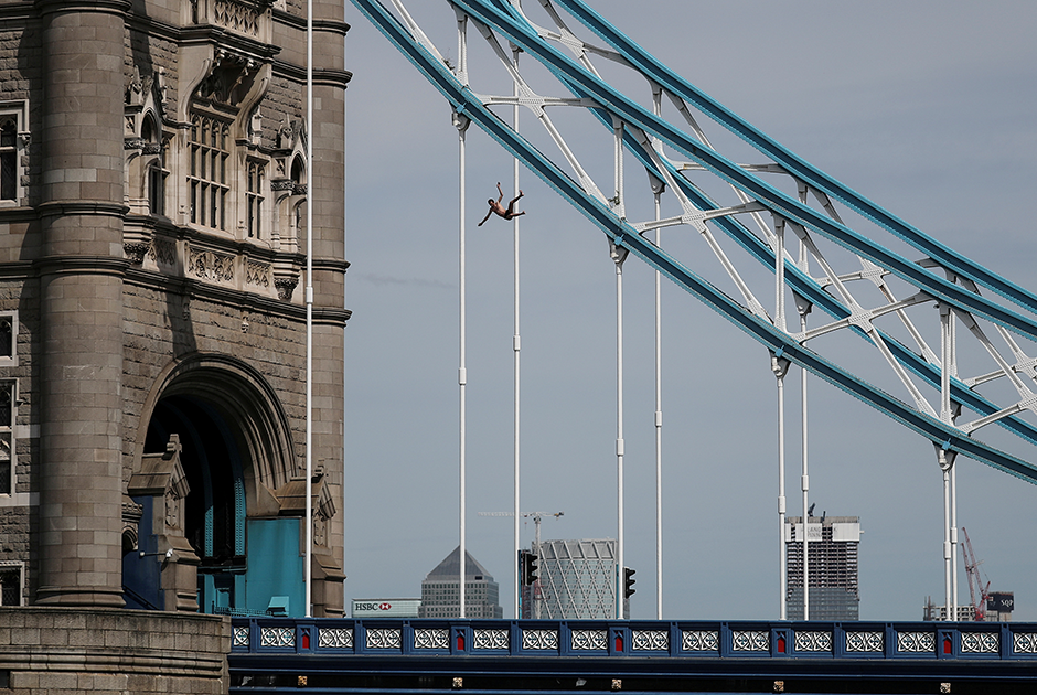 Чтобы поймать в объектив этот прыжок с Тауэрского моста 1 июня 2019 года, фотограф Reuters Алкис Константинидис несколько минут смотрел в видоискатель, не двигаясь. О чрезвычайной ситуации ему сообщил коллега Дилан Мартинес. Репортер успел добраться до берега Темзы, пока мужчина еще стоял на мосту. По его словам, падение длилось несколько секунд под вопли собравшихся зевак, а когда несчастный упал в воду на спину, раздался глухой удар. «Я не ожидал, что он переживет это падение без травм, но, к счастью, когда спасатели бросились к нему, он поплыл к их лодке», — пояснил Константинидис.