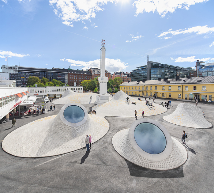 Музей Амос Рекс расположен на площади Ласипалатси в Хельсинки (Финляндия). Выставочный зал располагается под землей. Окна в галереях — на потолке. С поверхности они выглядят как холмы со световыми люками. До музея под площадью находился автовокзал.
