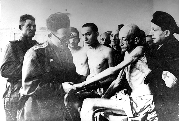 Советский военный врач осматривает выживших пленников Освенцима