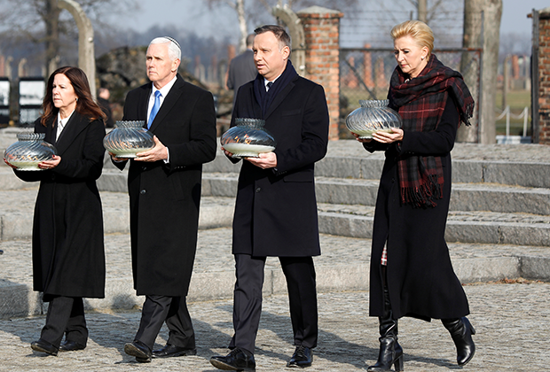 Вице-президент США Майк Пенс и президент Польши Анджей Дуда несут свечи к мемориалу жертв Освенцима, 2019 год