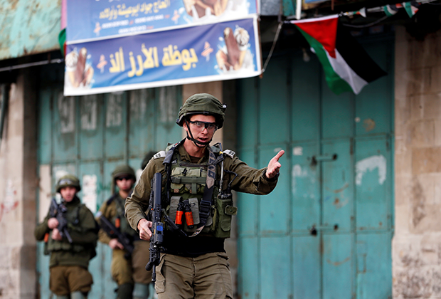 Израильский солдат во время протеста палестинцев из-за решения США признать законность нового еврейского квартала в городе Хеврон, конец 2019 года