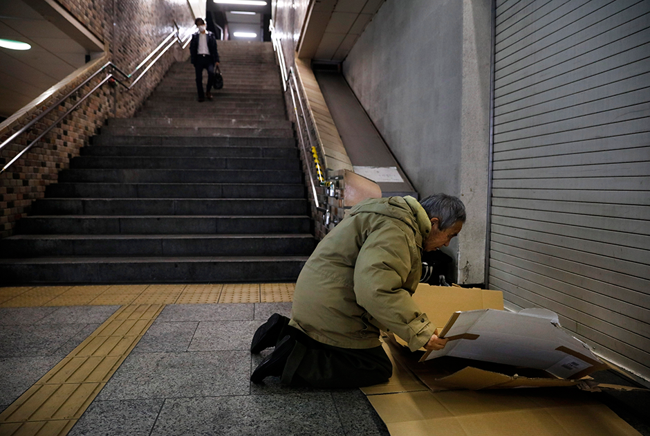 Бездомный устраивается на ночлег на станции Синдзюку