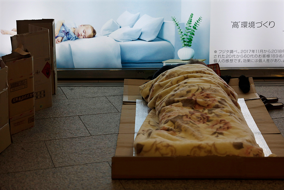 Бездомный спит на станции Синдзюку