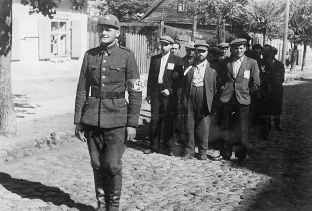 Полицай ведет евреев по вильнюсскому гетто. Июль 1941 года