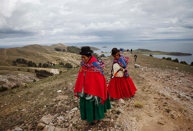 Местные женщины прогуливаются по берегу озера Титикака