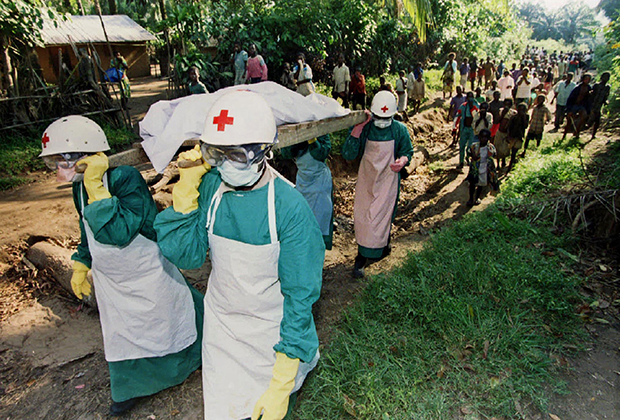 Работники Красного Креста несут тело женщины, которая погибла от вируса Эболы. Май, 1995 года