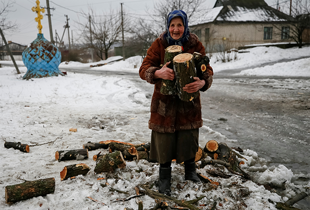 Пенсионерка собирает распиленное дерево на дрова. Авдеевка, подконтрольная Киеву часть Донбасса