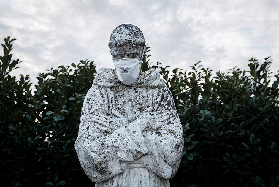 Кто-то из местных жителей надел защитную медицинскую маску даже на статую — фигура покровителя Италии, Святого Франциска, облачена в монашескую рясу, подпоясанную веревкой. Его голова опущена, а руки сложены на груди — как будто в молитве за итальянскую землю и живущих на ней людей.