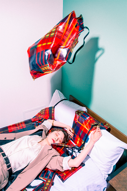 Японский фотограф Ханако Кимура (Hanako Kimura) выбрал необычный сюжет для своего снимка. В кадре запечатлена девушка, лежащая на кровати в номере одной из гостиниц Осаки и, по всей видимости, спящая. Вокруг нее — на подушках, одеяле и в воздухе — сумки из полипропилена в шотландскую клетку. Что именно хотел сказать автор своим снимком, остается загадкой.