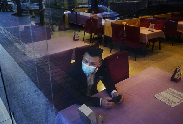 Официант в опустевшем пекинском ресторане