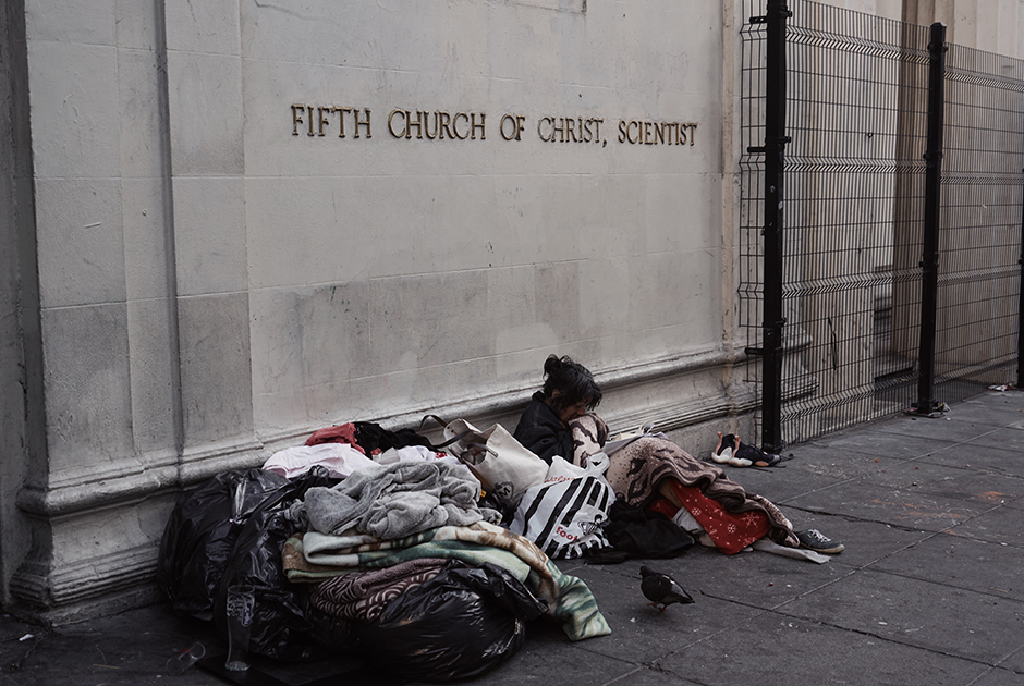 Бездомная женщина читает книгу в центре Сан-Франциско