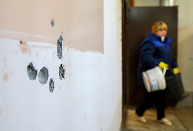 Места попадания пуль в стене на месте убийства в подъезде жилого дома 