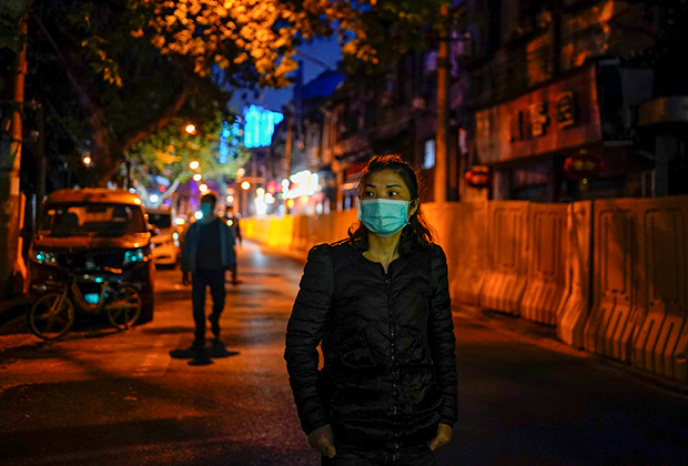 Женщина на улице Уханя 14 апреля 2020 года — через несколько дней после ослабления карантинных мер